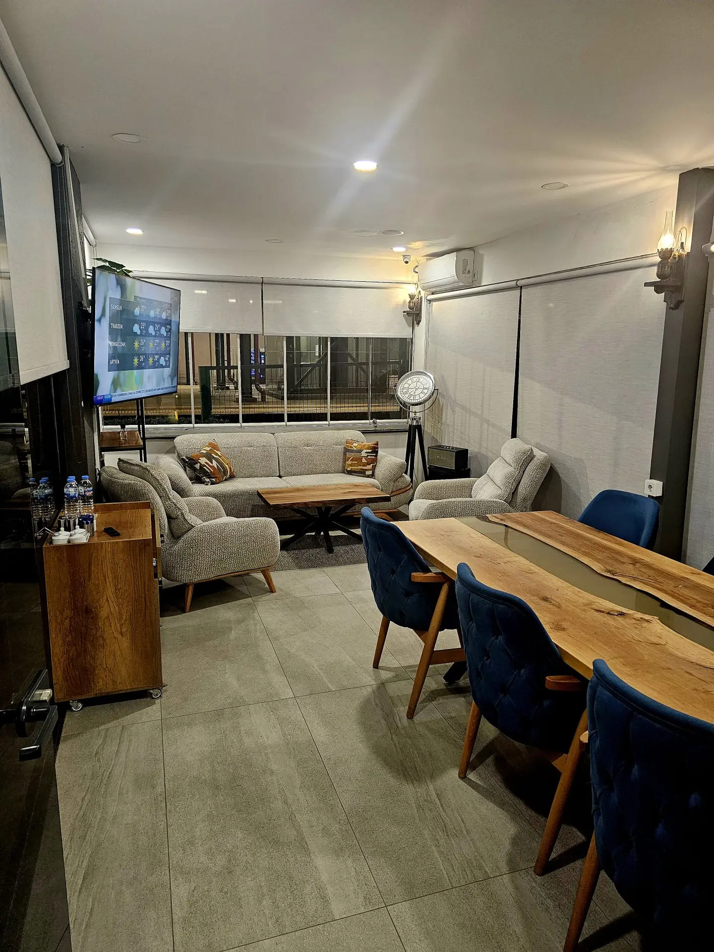 Salon oturma alanı, ahşap masalar ve rahat koltuklar